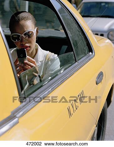 Woman sitting in a taxi and sending a text message View Large Photo Image Stock Image - Woman sitting in a taxi and sending a text message. Fotosearch