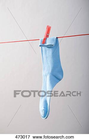 A blue sock hanging on a clothesline View Large Photo Image Stock Photo - A blue sock hanging on a clothesline. Fotosearch