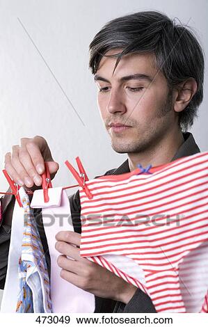 Stock Photo - A man hanging underwear on a clothesline. Fotosearch