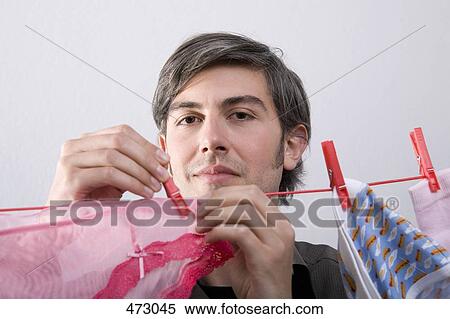 Stock Photography - A man hanging underwear on a clothesline. Fotosearch