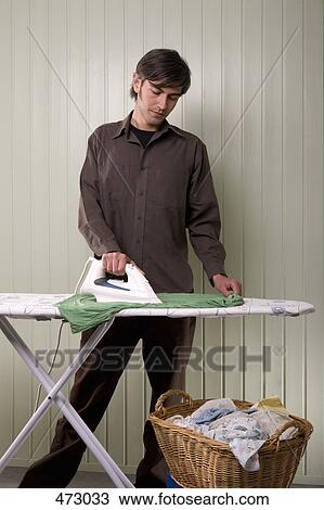 Stock Image - A man ironing. Fotosearch