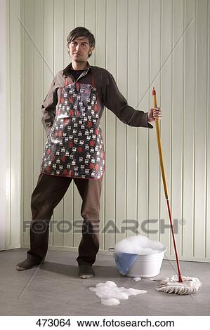 Picture - A man standing with a mop and bucket. Fotosearch