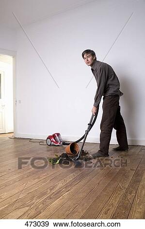A man vacuuming up soil from a spilt potted plant View Large Photo Image Stock Photo - A man vacuuming up soil from a spilt potted plant. Fotosearch