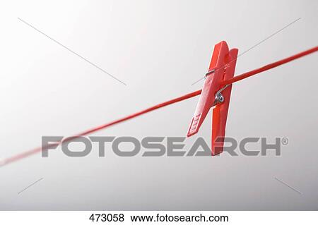 A red clothes peg upside down on a clothes line View Large Photo Image Stock Photo - A red clothes peg upside down on a clothes line. Fotosearch