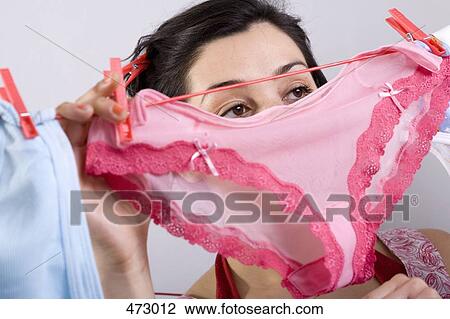 A woman hanging underwear on a clothesline View Large Photo Image Stock Image - A woman hanging underwear on a clothesline. Fotosearch