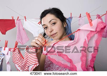 A woman hanging underwear on a clothesline View Large Photo Image Stock Image - A woman hanging underwear on a clothesline. Fotosearch