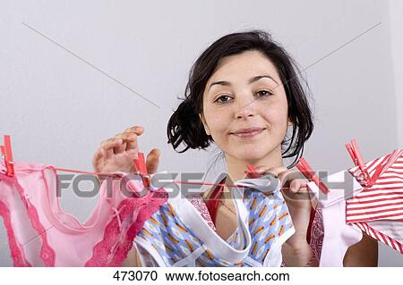 Stock Image - A woman hanging underwear on a clothesline. Fotosearch