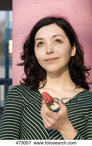 A woman holding a strawberry View Large Photo Image Stock Photo - A woman holding a strawberry. Fotosearch