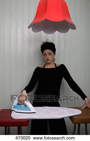 A woman holding an iron on an ironing board between two stools View Large Photo Image Stock Image - A woman holding an iron on an ironing board between two stools. Fotosearch