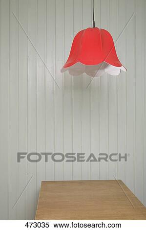 Stock Photography - Lamp shade hanging above a wooden table. Fotosearch