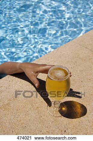 A man reaching for a glass of beer from a swimming pool View Large Photo Image Stock Image - A man reaching for a glass of beer from a swimming pool. Fotosearch