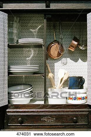 Stock Image - Cook wear and crockery in a cabinet. Fotosearch