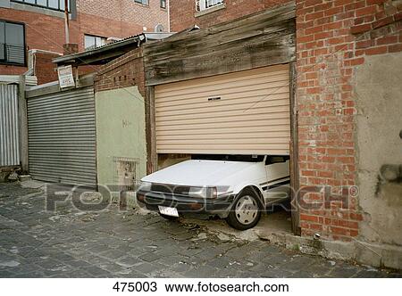 Stock Image - A car poking through a garage door. Fotosearch