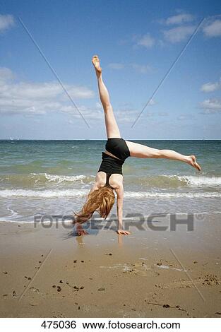 A woman doing a cartwheel on a beach View Large Photo Image Stock Photograph - A woman doing a cartwheel on a beach. Fotosearch
