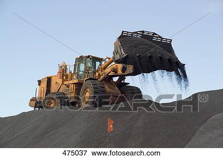 An earth mover pouring gravel View Large Photo Image Stock Photo - An earth mover pouring gravel. Fotosearch