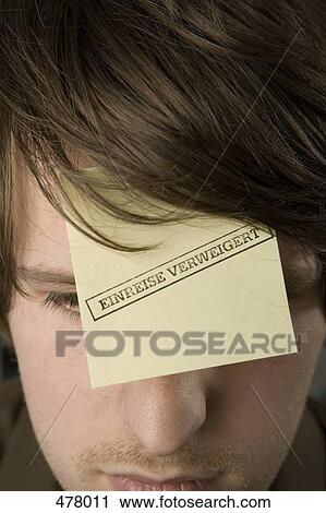 Stock Image - A man with an adhesive note on his forehead stamped 'Denied Entry'. Fotosearch