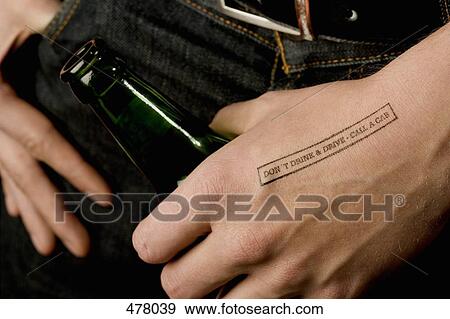 Close-up of a man holding a beer bottle with a rubber stamp on his hand View Large Photo Image Stock Photo - Close-up of a man holding a beer bottle with a rubber stamp on his hand. Fotosearch