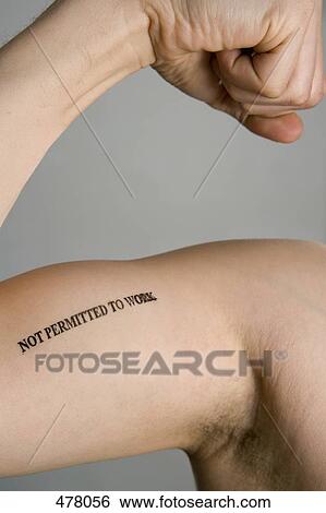 Stock Photograph - Detail of a man's bicep stamped 'Not permitted to work'. Fotosearch