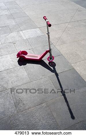 Stock Image - A pink scooter on the pavement. Fotosearch