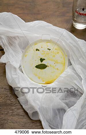 Stock Photograph - An anthropomorphic face on a dirty food carton. Fotosearch