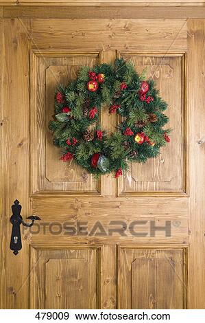 Christmas wreath hanging on a door View Large Photo Image Stock Photo - Christmas wreath hanging on a door. Fotosearch