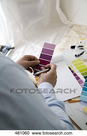Stock Image - A man comparing color samples. Fotosearch
