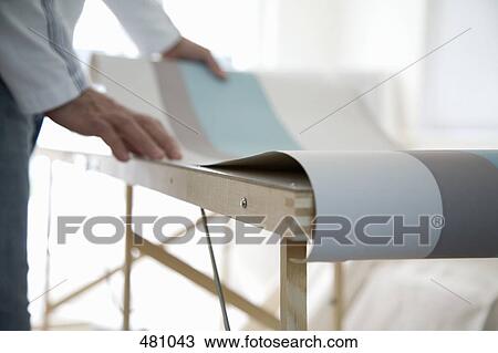 A man looking at wallpaper on a table View Large Photo Image Stock Image - A man looking at wallpaper on a table. Fotosearch