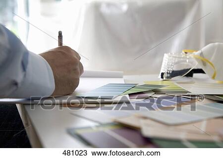 A man sitting at a table with color samples View Large Photo Image Stock Image - A man sitting at a table with color samples. Fotosearch