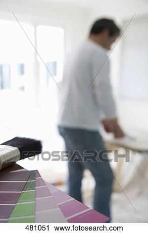 Stock Image - A man standing with decorating equipment. Fotosearch