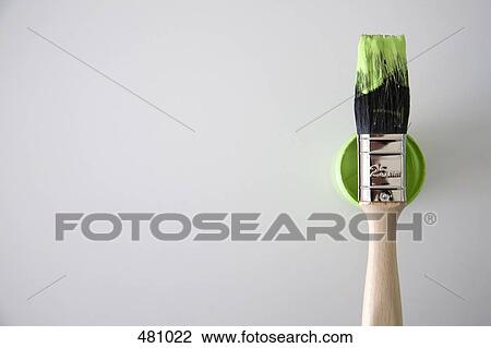 Stock Image - A paintbrush on top of a paint tin. Fotosearch