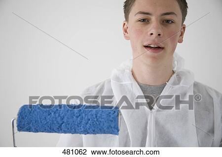 A teenage boy holding a paint roller and wearing overalls View Large Photo Image Stock Image - A teenage boy holding a paint roller and wearing overalls. Fotosearch