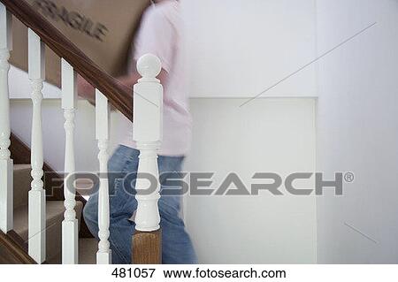 Stock Photo - Carrying a box up the stairs. Fotosearch