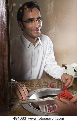 A cashier selling tickets at a box office View Large Photo Image Stock Image - A cashier selling tickets at a box office. Fotosearch