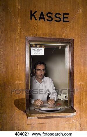 A cashier sitting in a box office View Large Photo Image Stock Photo - A cashier sitting in a box office. Fotosearch