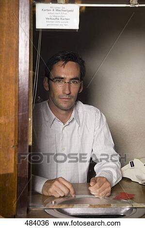 A cashier sitting in a box office View Large Photo Image Stock Photograph - A cashier sitting in a box office. Fotosearch