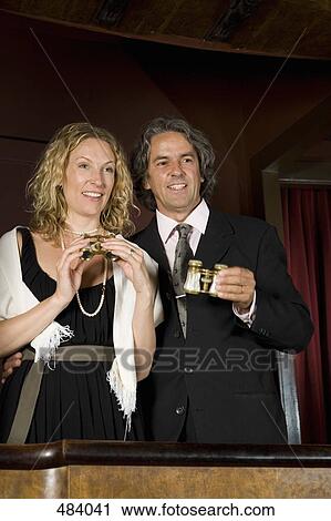 A couple holding binoculars in a theater box View Large Photo Image Stock Image - A couple holding binoculars in a theater box. Fotosearch