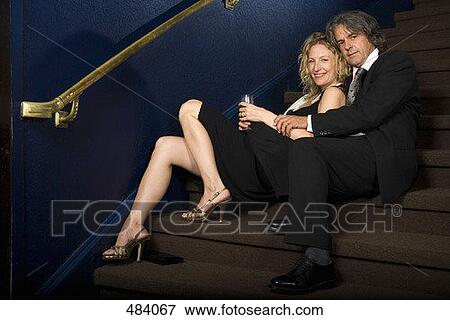 A couple sitting together on a staircase in a theater View Large Photo Image Stock Photo - A couple sitting together on a staircase in a theater. Fotosearch