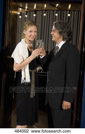 A couple toasting with champagne at a theater View Large Photo Image Stock Image - A couple toasting with champagne at a theater. Fotosearch