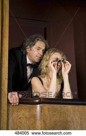 A couple using binoculars in a theater box View Large Photo Image Stock Photography - A couple using binoculars in a theater box. Fotosearch
