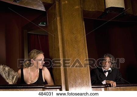 Stock Image - A man and a woman looking at each other from separate theater boxes. Fotosearch