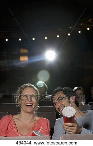A mid adult couple laughing in a movie theater View Large Photo Image Picture - A mid adult couple laughing in a movie theater. Fotosearch