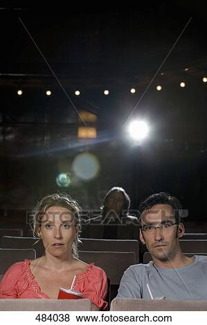 A mid adult couple sitting in a movie theater View Large Photo Image Stock Photo - A mid adult couple sitting in a movie theater. Fotosearch