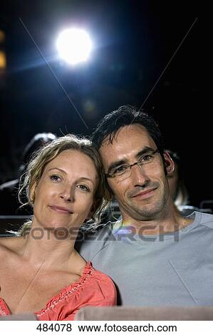 A mid adult couple sitting together in a movie theater View Large Photo Image Stock Photo - A mid adult couple sitting together in a movie theater. Fotosearch