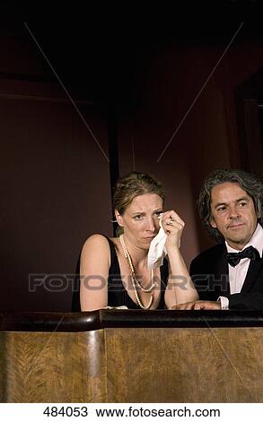 A woman crying whilst sitting with a man in a theater box View Large Photo Image Stock Image - A woman crying whilst sitting with a man in a theater box. Fotosearch