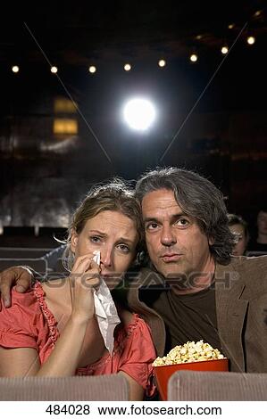 A woman crying whilst sitting with a man in a movie theater View Large Photo Image Stock Photo - A woman crying whilst sitting with a man in a movie theater. Fotosearch