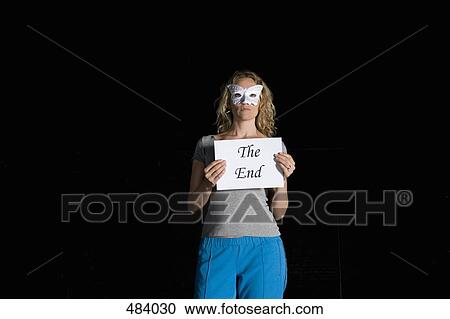 Stock Image - A woman holding a sign for 'The End'. Fotosearch