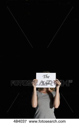 A woman holding a sign for 'The End' View Large Photo Image Stock Photo - A woman holding a sign for 'The End'. Fotosearch
