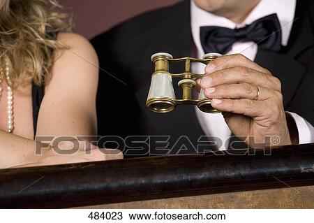 Detail of a couple with binoculars in a theater box View Large Photo Image Stock Image - Detail of a couple with binoculars in a theater box. Fotosearch
