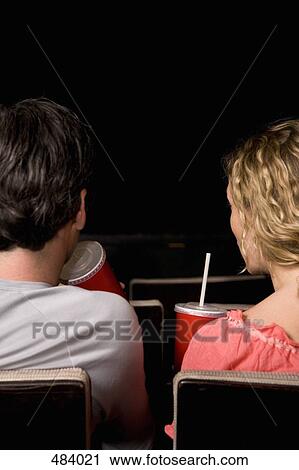 Rear view of a mid adult couple sitting together in a movie theater View Large Photo Image Stock Image - Rear view of a mid adult couple sitting together in a movie theater. Fotosearch