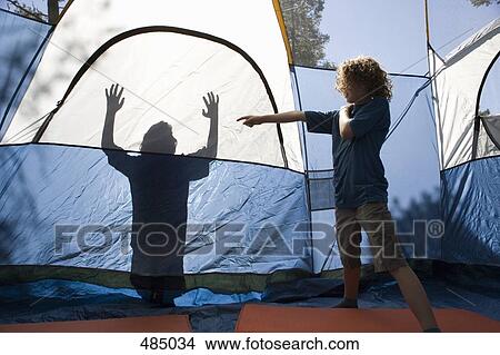 A young boy pointing to a shadow on a tent View Large Photo Image Picture - A young boy pointing to a shadow on a tent. Fotosearch